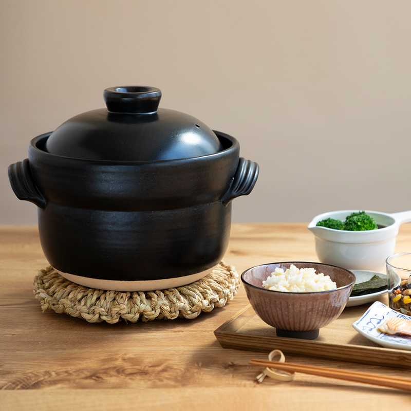 A product image of the Iga-yaki Goemon Donabe Rice Pot, showcasing its semi-matte black glaze, traditional shape, and twisted clay handles.