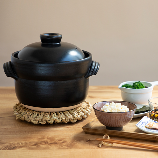 A product image of the Iga-yaki Goemon Donabe Rice Pot, showcasing its semi-matte black glaze, traditional shape, and twisted clay handles.