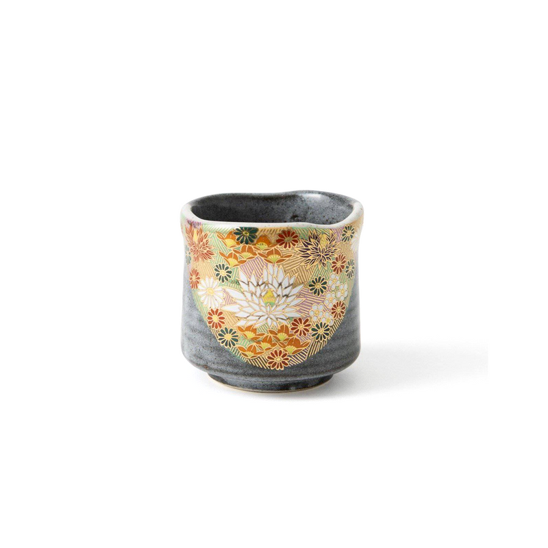 The Hanazume Kutani handmade teacup, showing its intricate, hand-painted floral design with gold detailing covering the surface against a soft grey background.