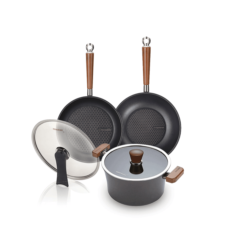 The 5-piece Happycall Crocodile Graphene nonstick induction cookware set, including a frypan, wok, pot, and two glass lids, featuring wood-style handles and hexagonal patterned surfaces.
