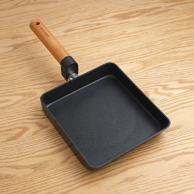 The 21cm Happycall Forest series tamagoyaki pan, showing its dark textured nonstick surface and light wood handle, angled on a white background.