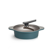 The low 24cm Happycall Onde ceramic nonstick induction pot in an ocean green finish, shown with its self-standing tinted glass lid and featuring a ridged exterior.

