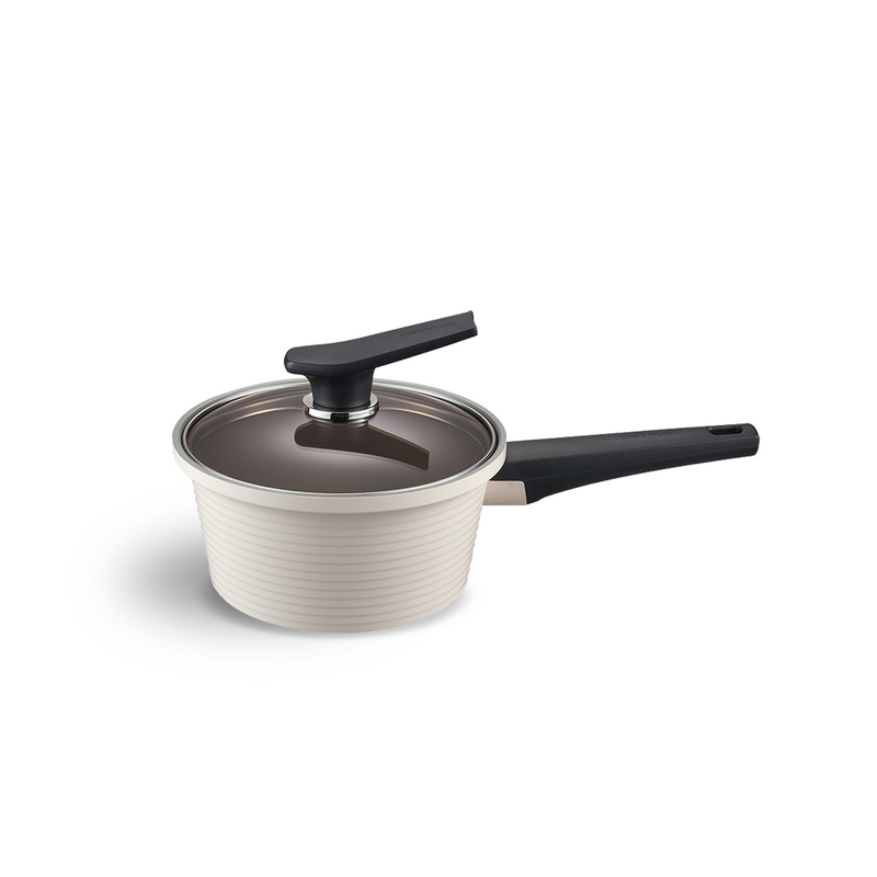 The 18cm Happycall Onde ceramic nonstick induction saucepan in an ivory finish, shown with its self-standing tinted glass lid and featuring a ridged exterior.
