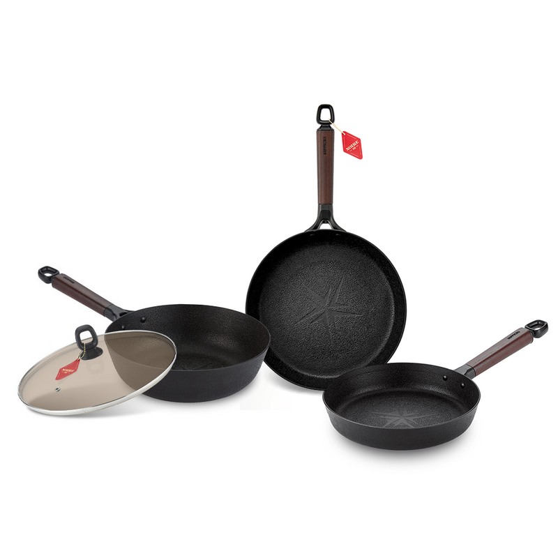 The 4-piece Happycall Noire Titanium Plus cookware set, featuring a 22cm frypan, 26cm frypan, 26cm wok, and a tinted glass lid, all with textured black surfaces and dark wood-style handles.

