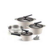 The 9-piece Happycall Onde ceramic nonstick induction pot set in an ivory finish, showing the 18cm saucepan, 24cm pot, 28cm stockpot, a steamer, and pot holders.
