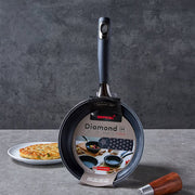 Happycall Solid Diamond nonstick induction frypan 20cm standing upright in its Diamond IH packaging sleeve, beside a Korean pancake on a white plate.