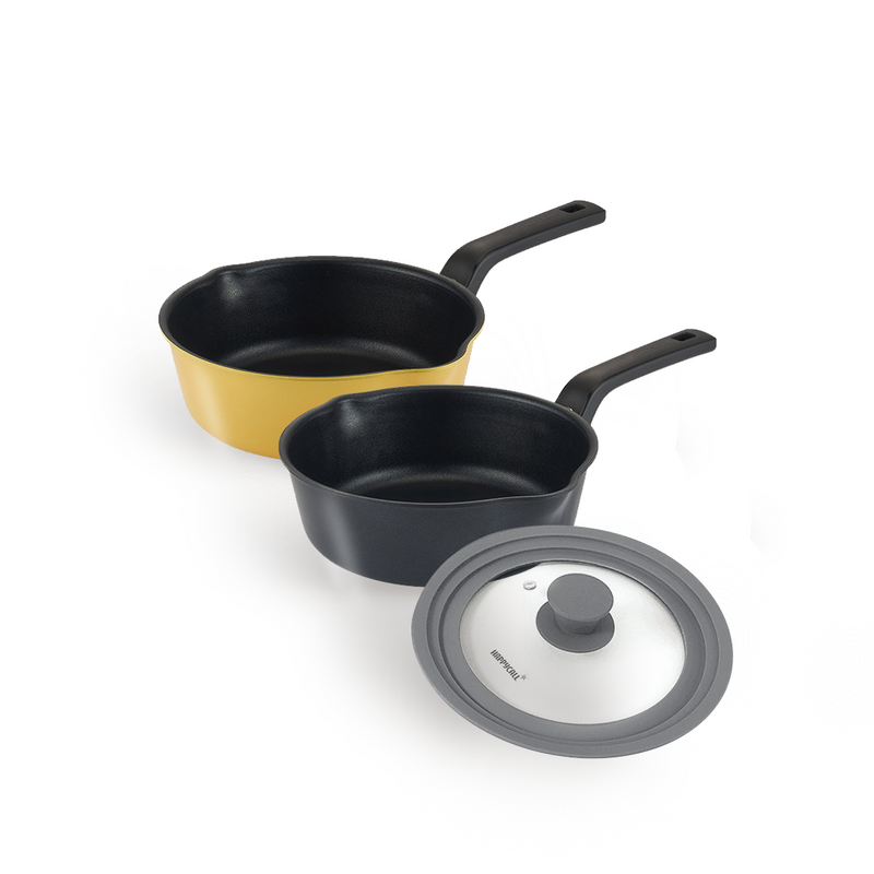 The 3-piece Happycall Flex nonstick saucepan set, showing the 22cm yellow saucepan, the 20cm black saucepan, and the grey VIVA silicone multi-lid.
