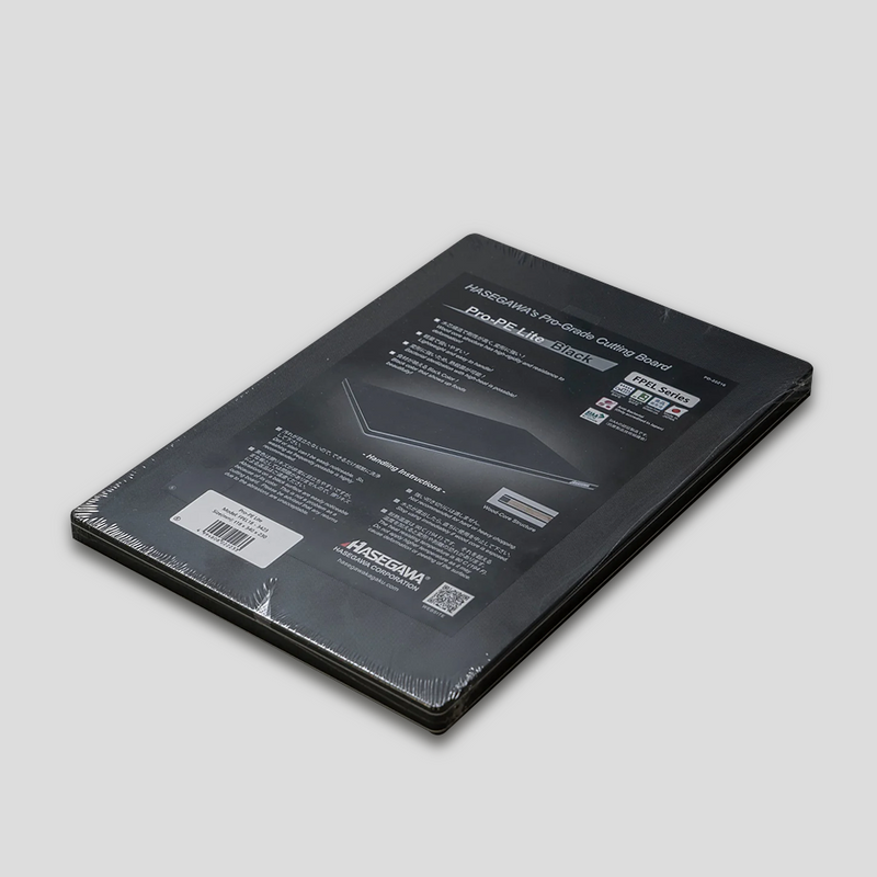 The Hasegawa Pro-PE Lite Black FPEL Series cutting board in its original black and white packaging, showing "HASEGAWA'S Pro-Grade Cutting Board" text.
