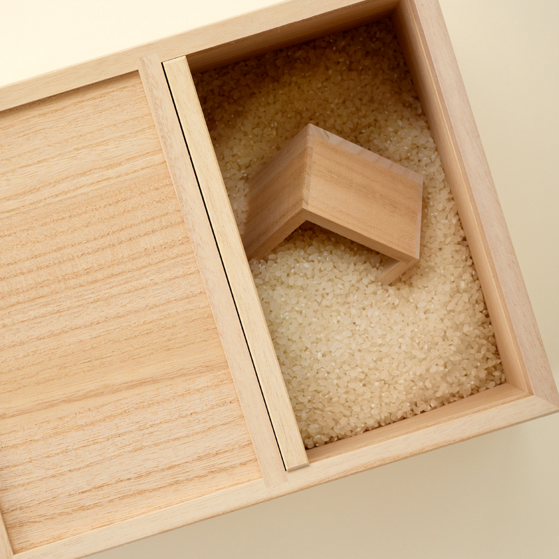 An interior view of the empty Hinoki rice box, with Japanese text that reads 'A rice box that preserves the freshness and deliciousness of rice'.

