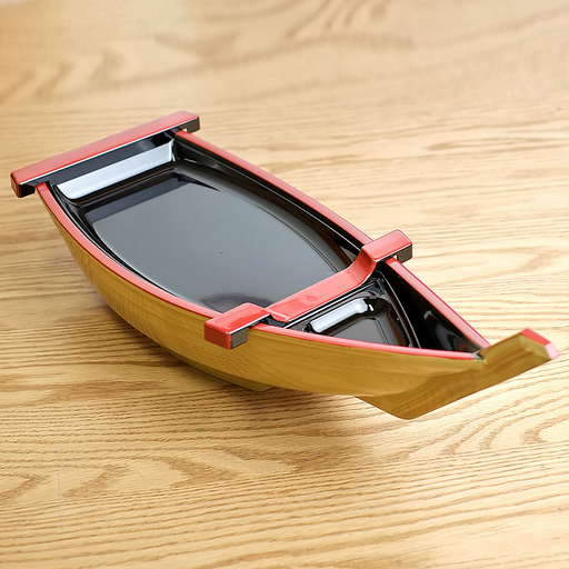 Wooden toy boat with red trim on a wooden surface