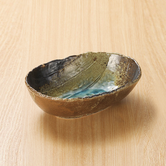 Earthen oval bowl with a turquoise interior and textured brown exterior, reflecting Japanese Sansai design.