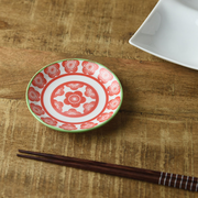 Miyama Japonesque Pink Blossom mini plate with red coral plum blossom pattern and green rim, shown on a wooden surface beside chopsticks
