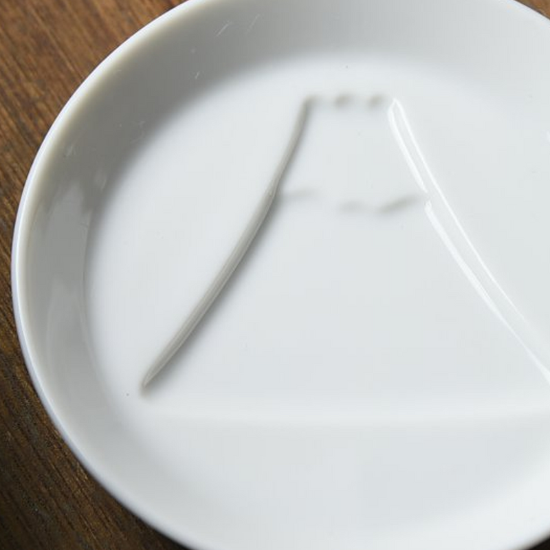 A detailed close-up of the Kageasobi plate, showing the embossed outline of Mount Fuji on the white porcelain.

