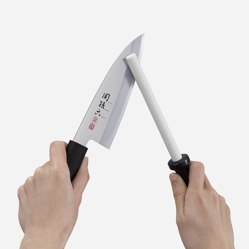 A demonstration showing the Kai ceramic rod being used to sharpen the edge of a Japanese kitchen knife.
