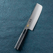 The Kai Seki Magoroku Premium Nakiri Knife (165mm) on a textured blue surface, showcasing its traditional rectangular blade for vegetables and composite wood handle.
