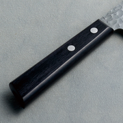 A detailed close-up of the Kaneyoshi knife's black laminated reinforced wood handle and stainless steel rivets.

A detailed close-up of the Kaneyoshi knife's black laminated reinforced wood handle and stainless steel rivets.

