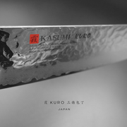 A macro close-up of the knife blade, showing the Kasumi Kuro brand engraving, Damascus layers, and hammered texture.