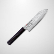 The Kasumi Kuro hammered Damascus Japanese Santoku knife, 170mm, showing its textured blade and dark octagonal handle, angled against a light grey background.
