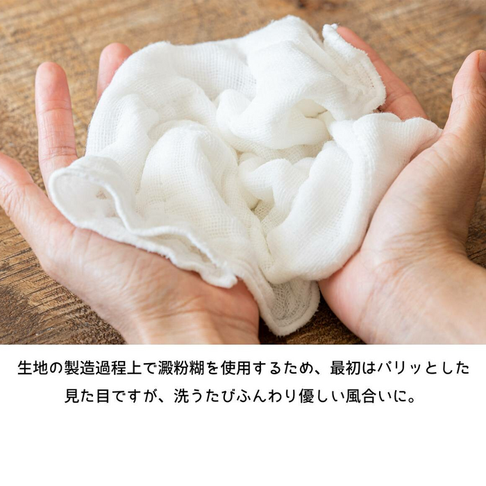 Close-up of hands holding the soft, textured Kayanuno Mt. Fuji Embroidered Cloth, illustrating its lightweight and absorbent fabric.