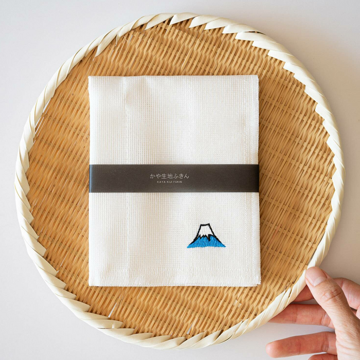 A beautifully presented Kayanuno Mt. Fuji Embroidered Cloth neatly folded on a wicker tray, showcasing its elegant packaging with a Mt. Fuji embroidery prominently displayed.