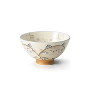 A side view of the Ko-dehiki Japanese Neko Cat Bowl, showing its beige powdered finish, charming cat face illustrations, and unglazed brown footed base.