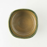 Top-down view of the Kochidori Japanese Matcha Bowl, displaying its unique rounded square shape and earthy brown interior.
