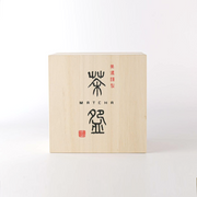 The traditional Japanese wooden gift box (kiribako) for a matcha bowl, showing calligraphy and a red seal stamp.







