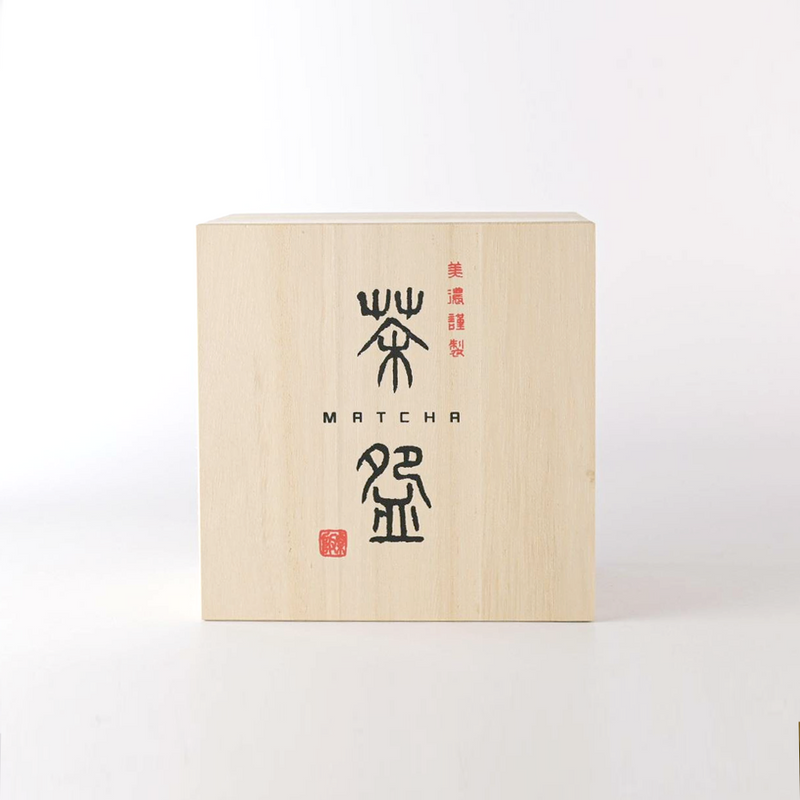 The traditional Japanese wooden gift box (kiribako) for a matcha bowl, showing calligraphy and a red seal stamp.







