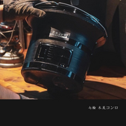 Person holding the Mikawa Portable Konro Grill in black, emphasizing its lightweight and portable features.