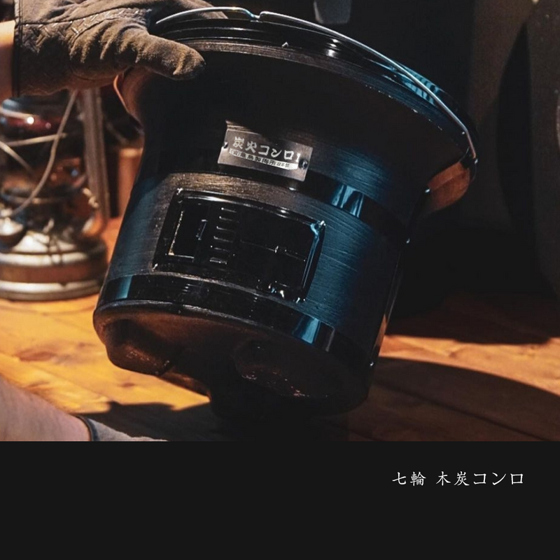 Person holding the Mikawa Portable Konro Grill in black, emphasizing its lightweight and portable features.