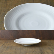 A composite image showing a close-up of the Kushime plate's textured lines and a side profile view of the plate on a wood surface.

