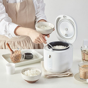 A woman serving freshly cooked rice from the LocknLock Macaron Mini Rice Cooker, demonstrating its ease of use and efficiency in a home kitchen setting.