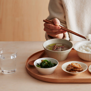 A person enjoying a healthy meal of rice, soup, and vegetables prepared using the LocknLock Macaron Mini Rice Cooker, illustrating its practicality for single servings.