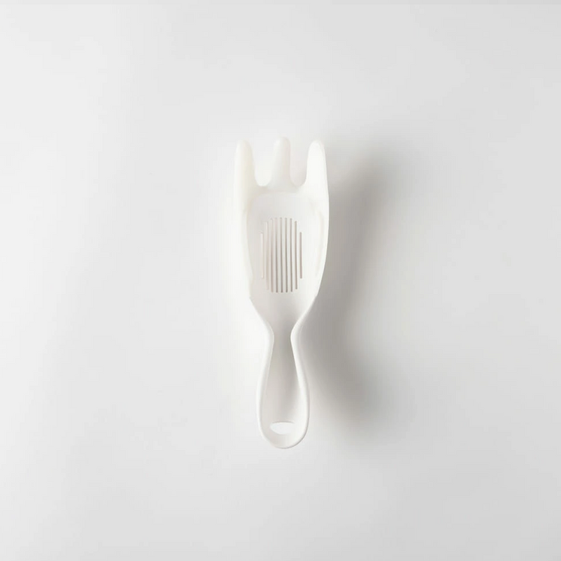 Using the Marna rice washer as a strainer against the side of a bowl to drain starchy water without losing any rice grains.