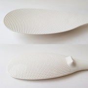 A two-part image showing close-ups of the Marna rice scoop: a top view of the non-stick embossed texture, and a side view of the foot that allows it to stand.