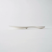 An elegant side profile of the Marna rice scoop, showing its thin paddle and curved handle design.