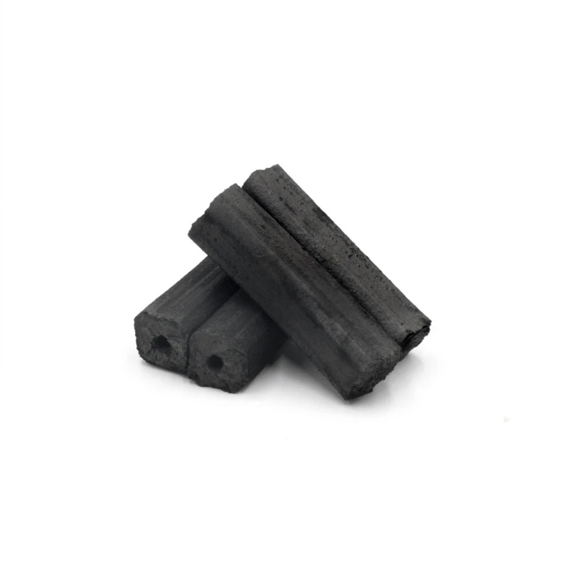 Multiple compressed binchotan logs with hollow cores, packed inside a cardboard box.