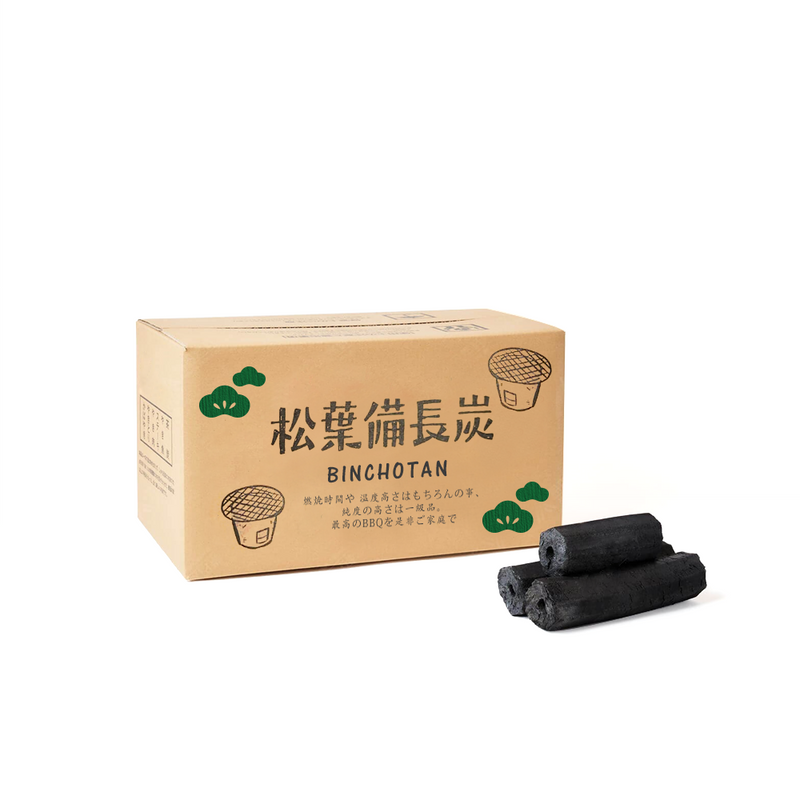 A cardboard box labeled ‘松葉備長炭’ (Matsuba Binchotan) alongside three compressed charcoal logs.