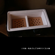 The interior of the Mikawa konro grill, showing the white diatomite insulation and terracotta fire boxes.


