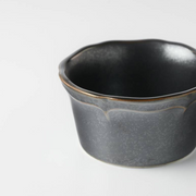 Top view of a grey ceramic mini bowl with a deep black interior, highlighting the round shape and smooth surface.