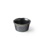 A dark grey ceramic mini bowl with a rustic gold rim, showing a subtle petal-shaped design, against a white background.