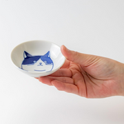 A hand holding the Shichita Mino Yaki Cat Mike Side Bowl to show its 9cm size.
