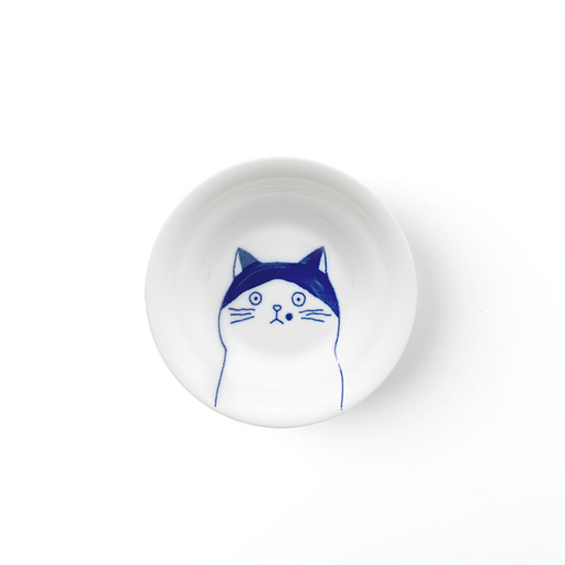 A top-down view of the Shichita Mino Yaki Cat Nora side plate, showing the wide-eyed, contemplative cat illustration on a white porcelain surface.
