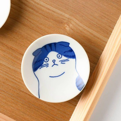 A top-down view of the Shichita Mino Yaki Cat Nora mini plate, showing the wide-eyed, contemplative cat illustration on a white porcelain surface.
