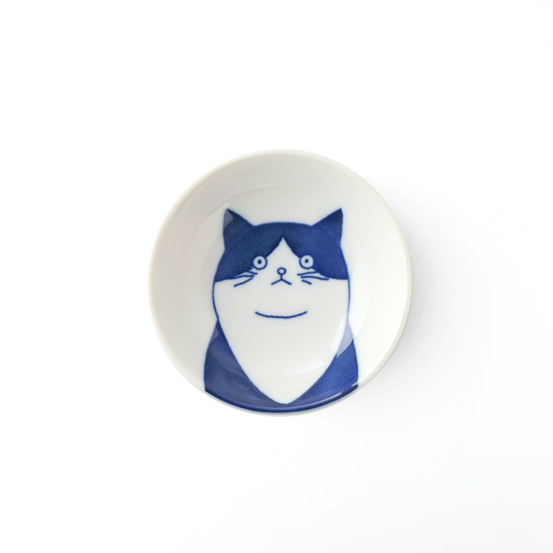A top-down view of the Shichita Mino Yaki Cat Tama side bowl, showing the friendly, rounded-face cat illustration on a white porcelain surface.