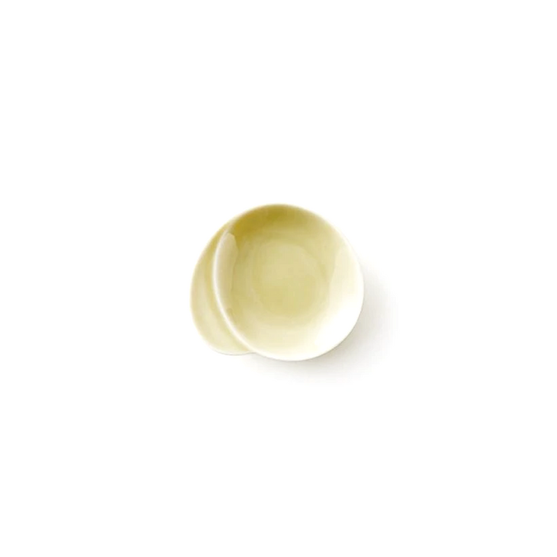 Miyama Gaku mini plate in warm pale yellow glaze with an organic asymmetric form featuring an integrated chopstick rest indent, shown against a white background
