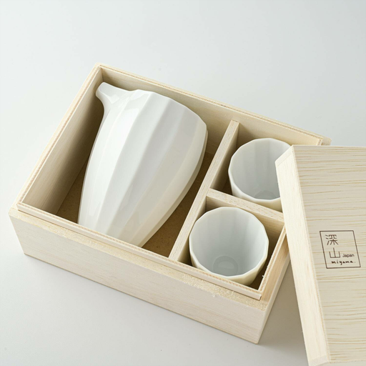 The Miyama Hibiki Series Sake Set displayed in a wooden gift box, showcasing a porcelain sake jug and two cups neatly arranged in compartments, highlighting the elegant white finish and textured design.