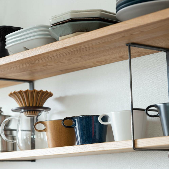 Miyama Metaphys Stamug in mustard colour on a shelf with other mugs.