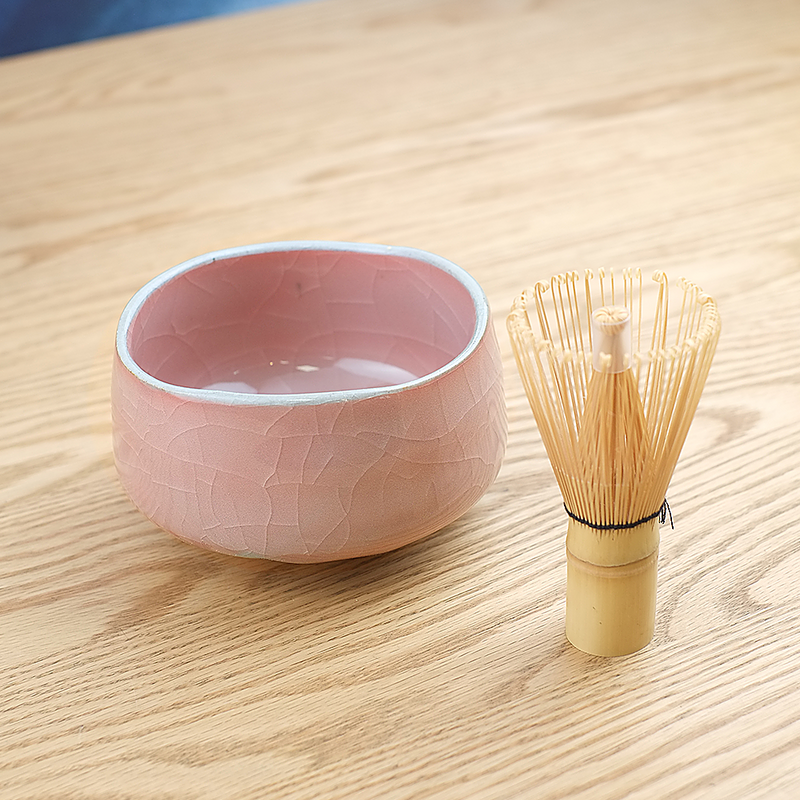 The Momoyama Red Crackle matcha bowl (chawan), featuring a vibrant reddish-pink crackle glaze, an irregular rim, and a partially unglazed foot. Made in Japan
