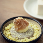 Close-up view of freshly grated wasabi on a ceramic grater plate.

